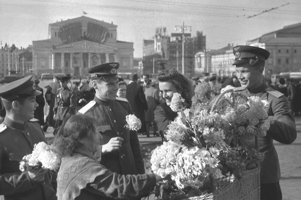 Женщины дарят цветы советским авиаторам в День Победы на площади Свердлова (ныне Театральная площадь) в Москве, 9 мая 1945 г. Источник фото: http://waralbum.ru