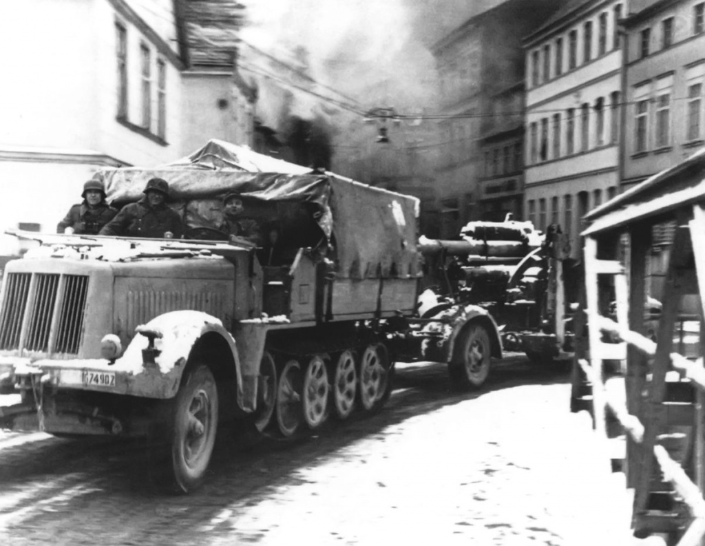 Немецкий полугусеничный тягач буксирует 88-миллиметровое зенитное орудие по городским улицам Штеттина, весна 1945 г. Источник фото: http://waralbum.ru